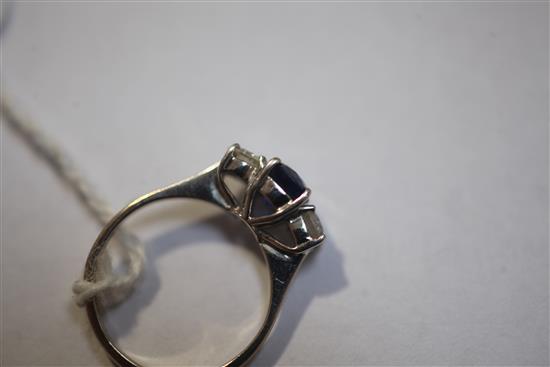 A modern 18ct white gold and three stone diamond and sapphire ring, size J.